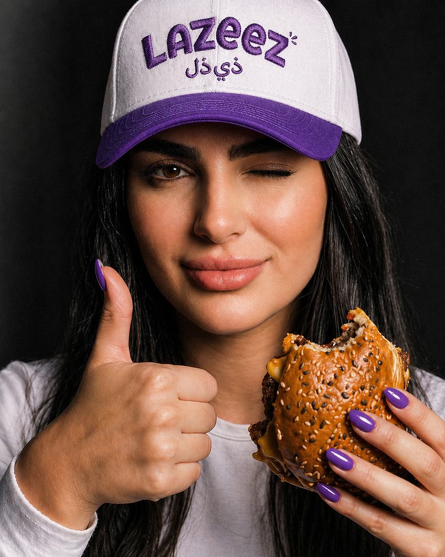 Customer wearing a Lazeez cap holding a burger